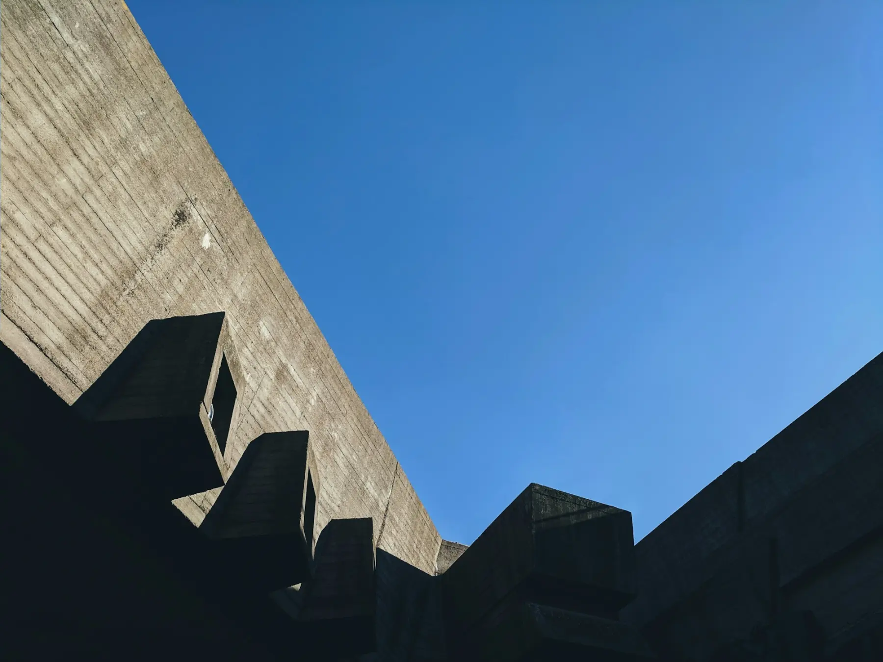 Façade en béton vue en contre-plongée sur ciel bleu